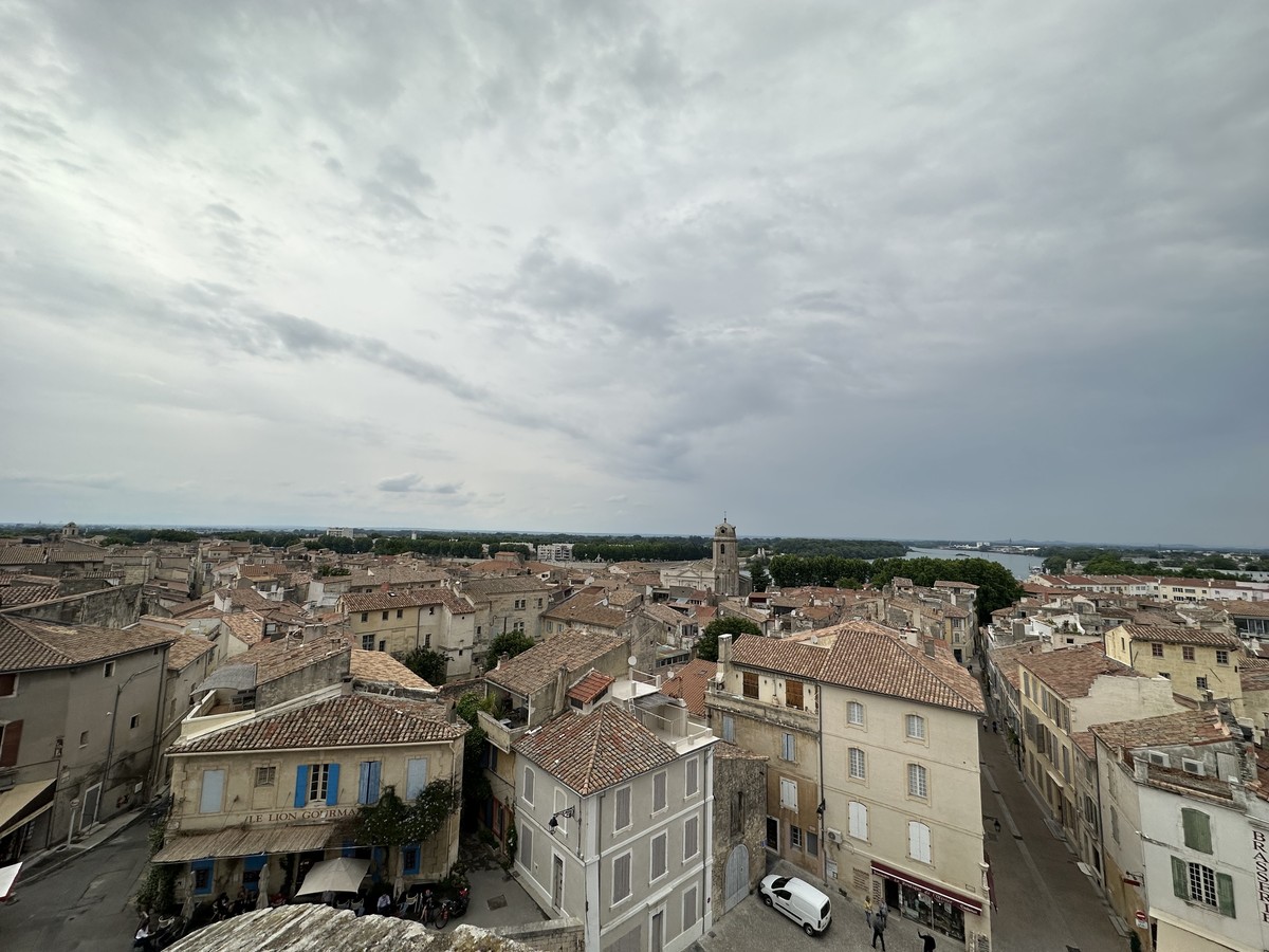 Panoramic view of Arles rooftops from the amphitheater showing terracotta tiles, stone buildings, and church towers