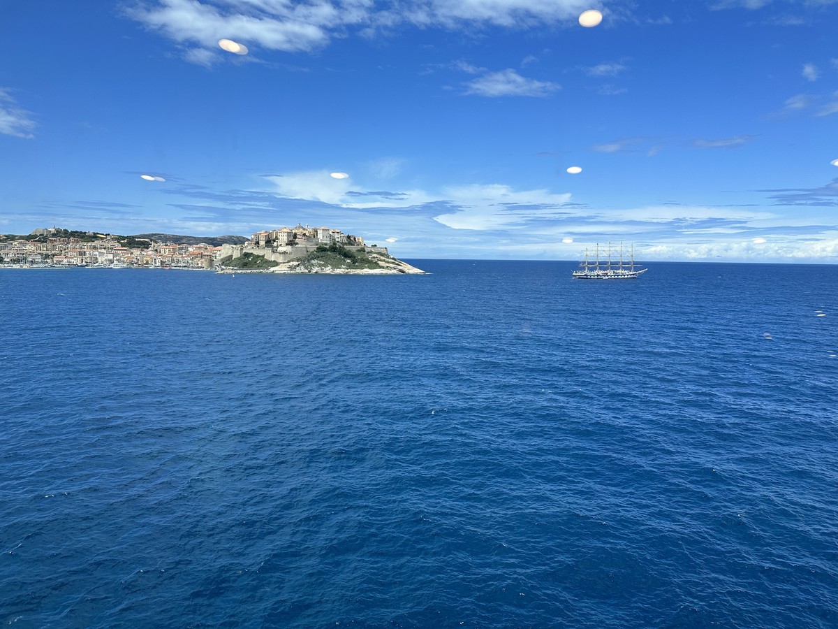 Approach to the citadel in Corsica with stone fortification walls rising above the harbor