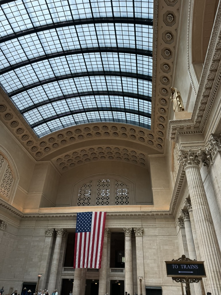 The grand hall of Chicago Union Station with its iconic skylight and American flag
