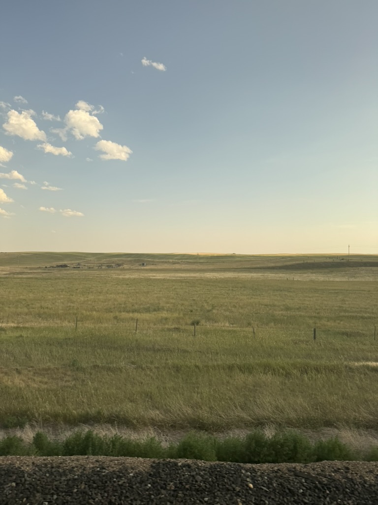 Rolling plains stretching to the horizon seen from the train window crossing middle America