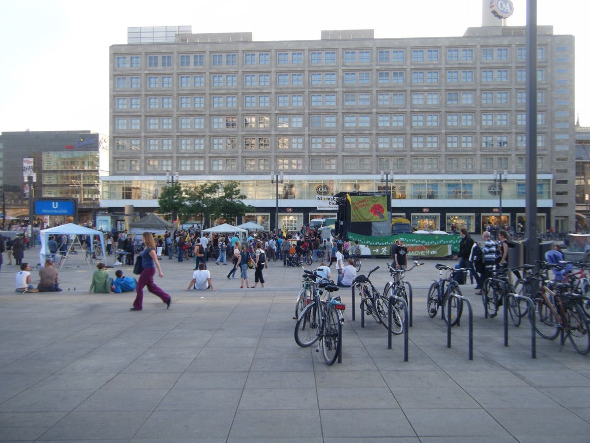 Alexanderplatz in Berlin at evening with crowds, bicycles, and shops