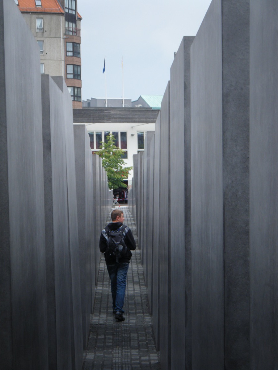 Walking between towering concrete stelae inside the Holocaust Memorial