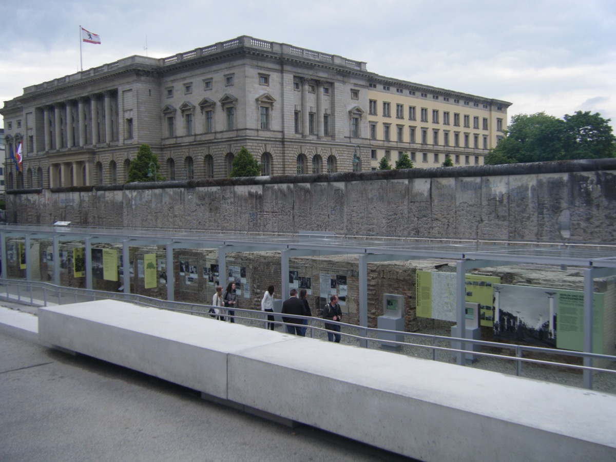 Topography of Terror outdoor exhibit with preserved Berlin Wall section and grand building behind