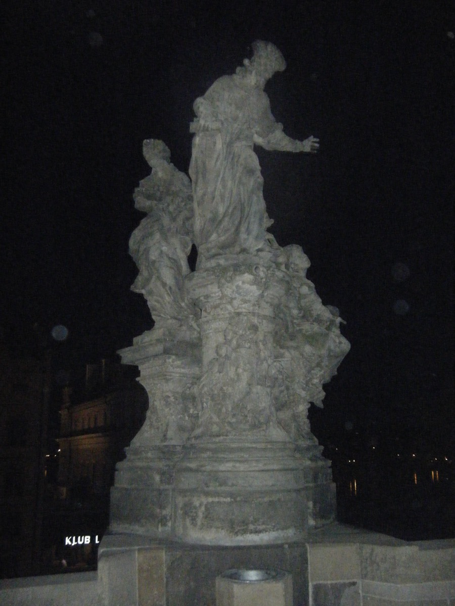 Baroque saint statue illuminated at night in Prague