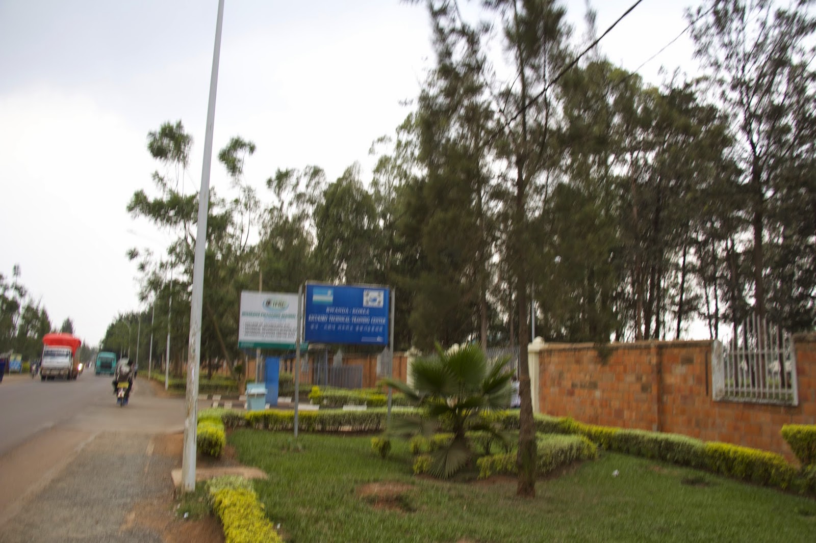 Street view of the ETO school campus entrance with signs and a brick perimeter wall