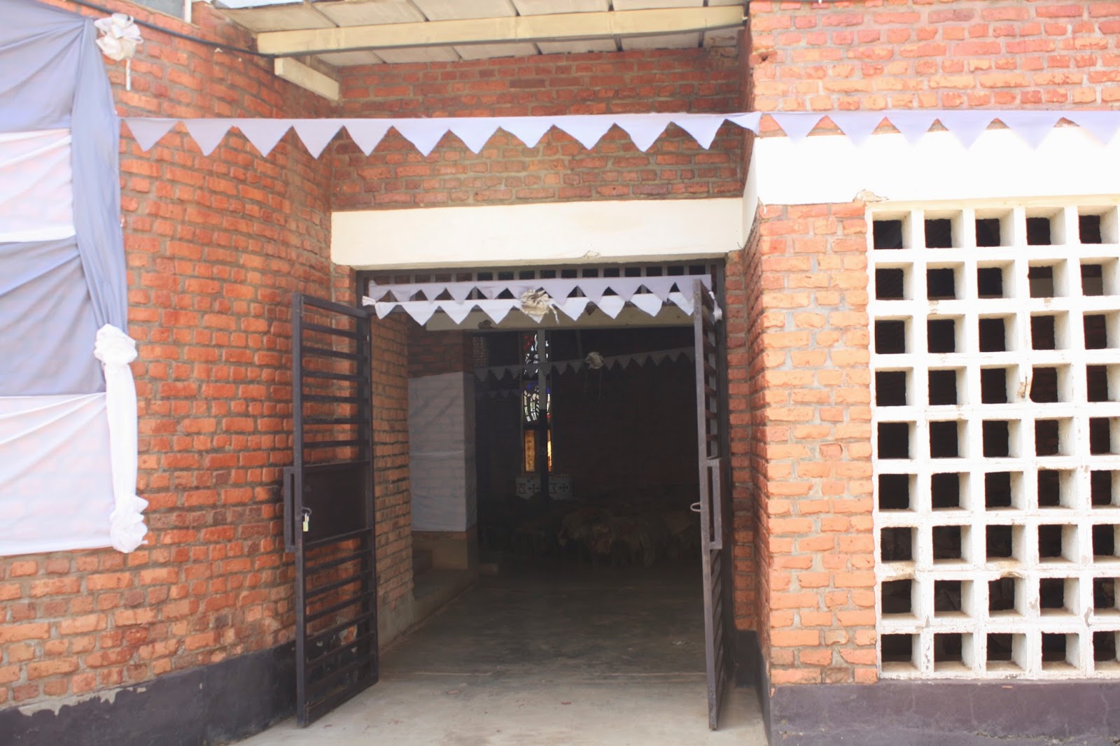Other gate with piles of clothes and altar visible inside