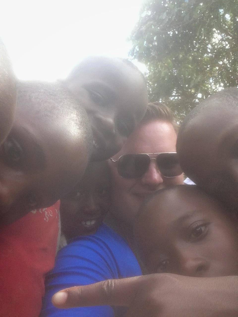 Michael taking a selfie with a growing crowd of Rwandan children