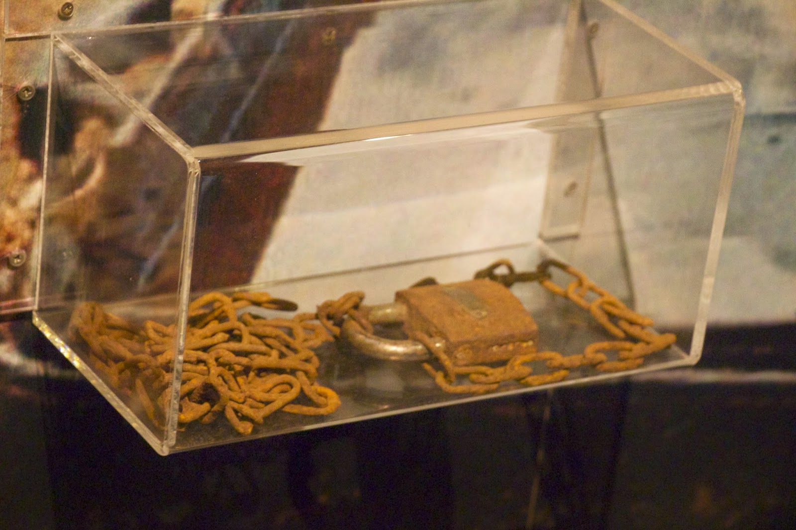 Rusty padlock and chains displayed in a clear case at the Kigali Genocide Memorial