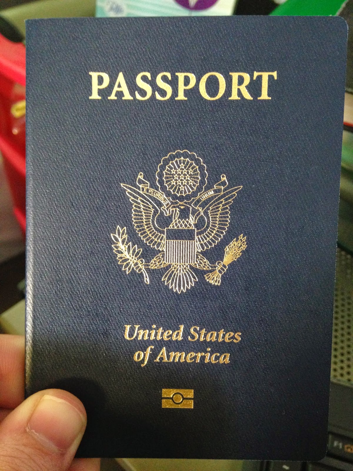A hand holding a United States of America passport