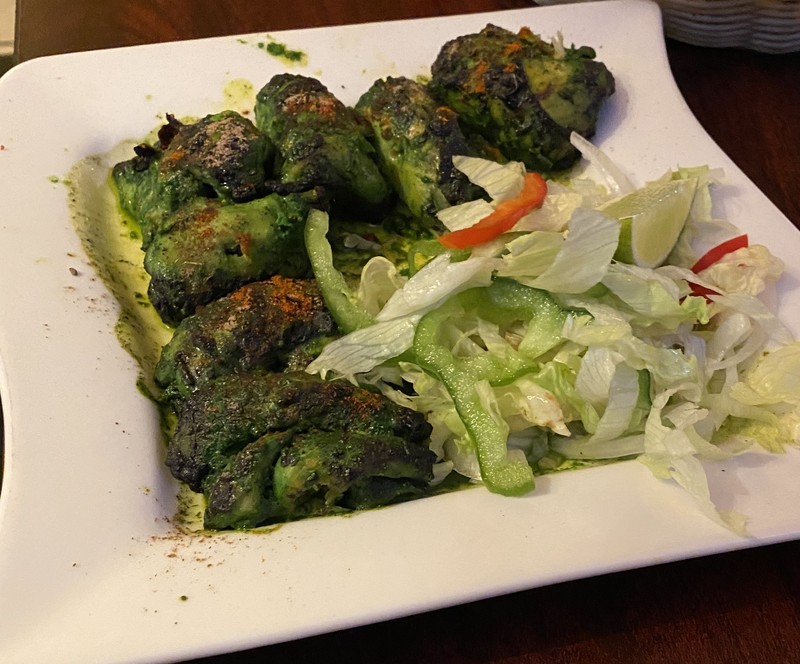 Green herb-crusted dish with side salad