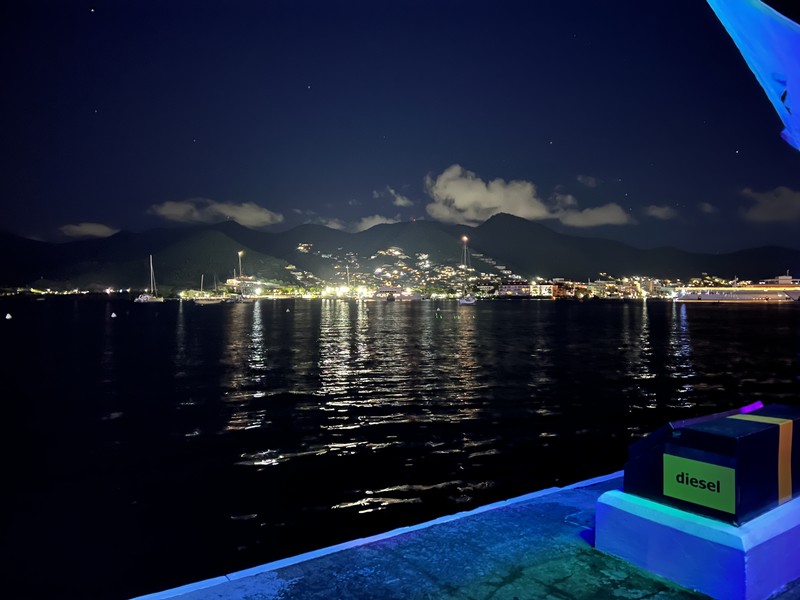Harbor at night with mountains lit up across the water