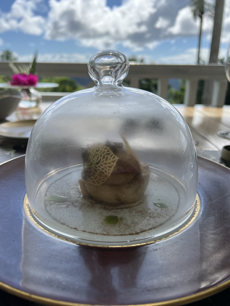 Fine dining dessert presented under a glass cloche