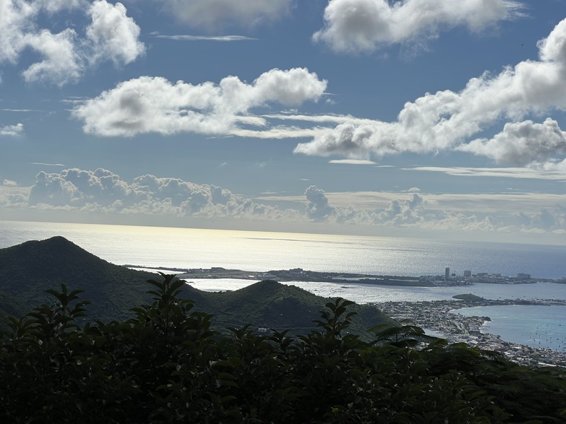 Panoramic view from Pic Paradis summit showing the island, ocean, hills, and towns below