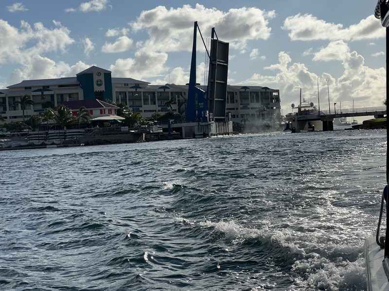 Simpson Bay drawbridge from the water, bridge raised, marina buildings behind