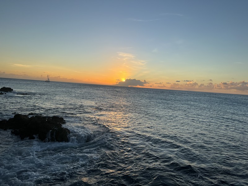 Sunset behind clouds with dramatic orange glow at the horizon