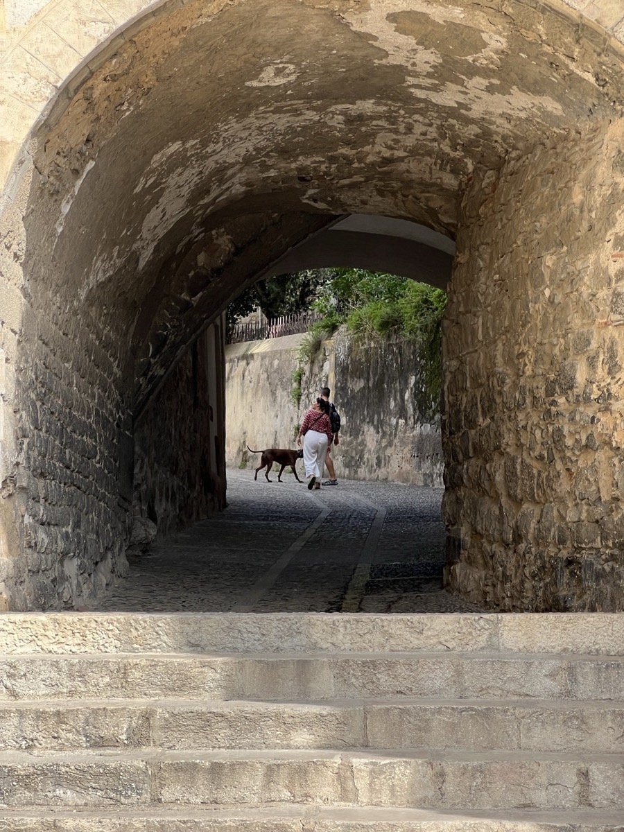 Stone archway framing cobblestone path in Girona old town
