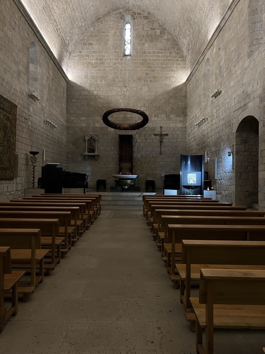 Interior of the Romanesque church with stone walls and arched windows