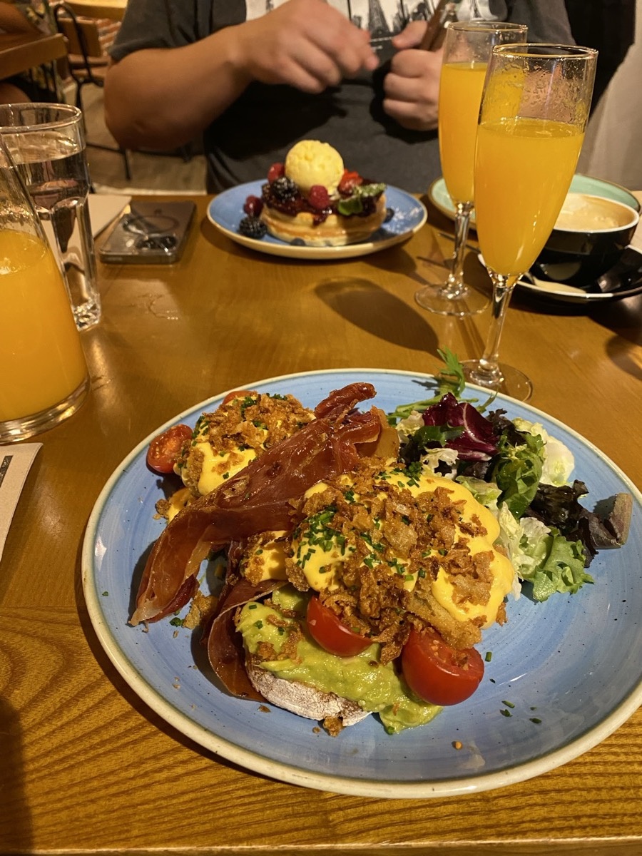 Brunch with eggs benedict, avocado, and mimosas