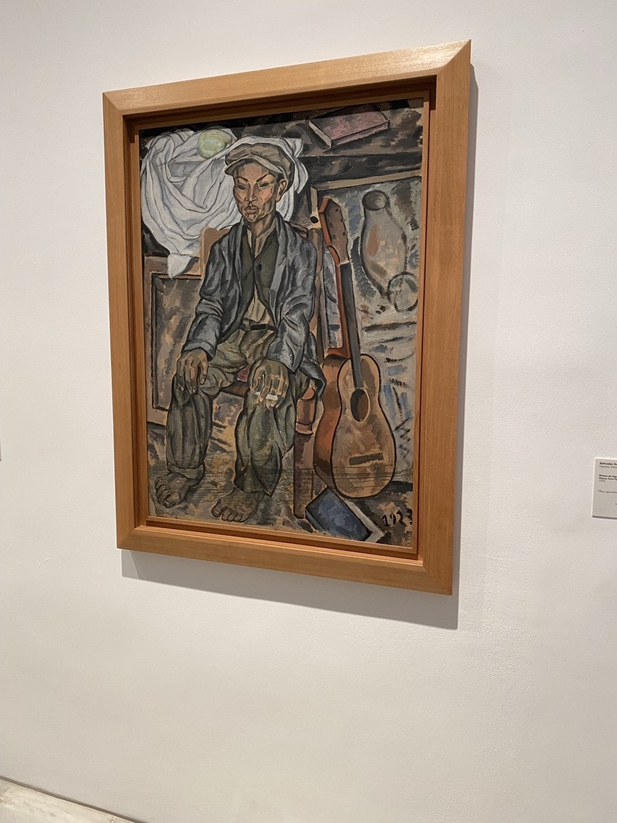 Post-cubist painting of a figure with a guitar in blue-grey tones