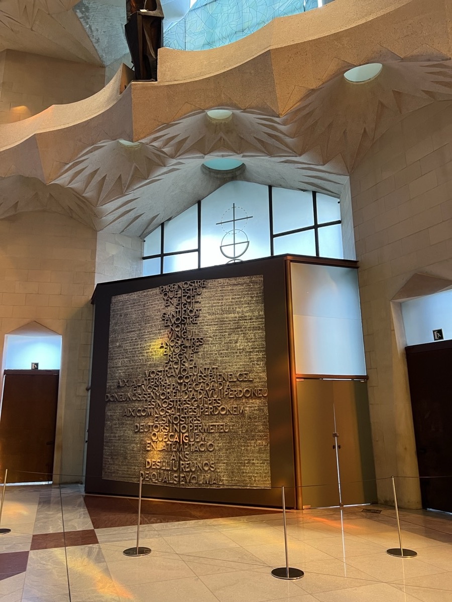 Large bronze door with inscribed text inside Sagrada Família