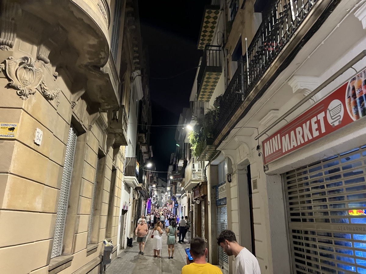 Narrow Sitges lane at night with warm lighting