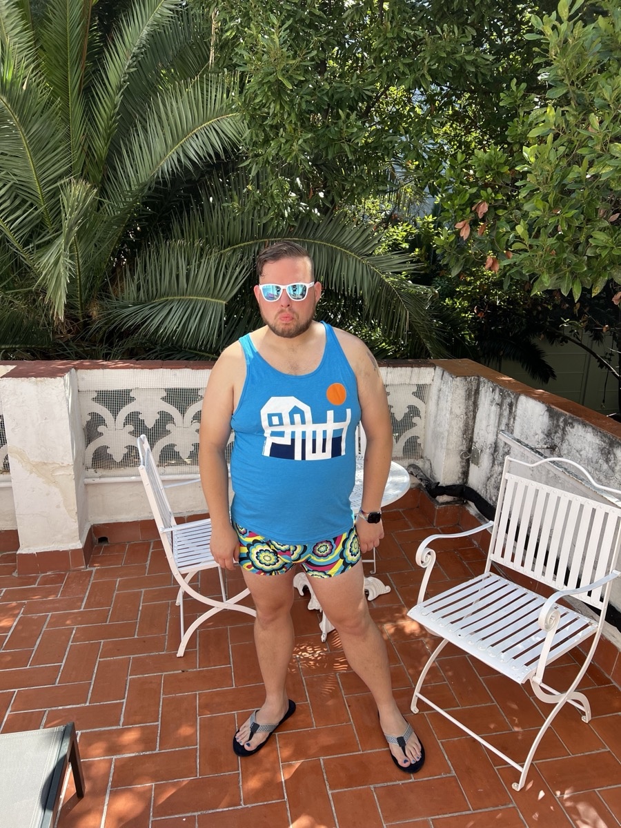 Michael standing on a terracotta patio with palm trees in Sitges